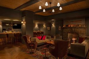 a living room with a couch and chairs and a bar at Grand Adirondack Hotel, Lake Placid, a Tribute Portfolio Hotel in Lake Placid