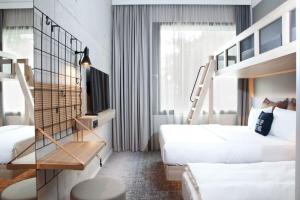 a hotel room with two beds and a staircase at Moxy Rust in Rust