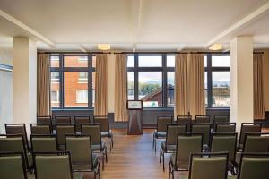 a room with chairs and a podium in a room with windows at Grand Adirondack Hotel, Lake Placid, a Tribute Portfolio Hotel in Lake Placid