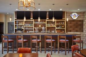 a bar in a restaurant with wooden stools at Four Points by Sheraton Houston Intercontinental Airport in Houston