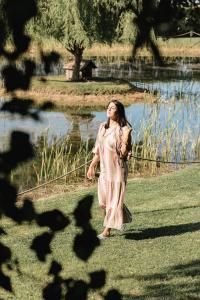 uma jovem a caminhar em frente a um lago em Sella&Mosca Casa Villamarina em Alghero