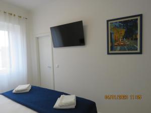 Un dormitorio con una cama con un televisor en la pared. en Peacock Apartment, en Split