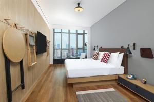 a bedroom with a white bed and a large window at Moxy Shanghai Xuhui in Shanghai