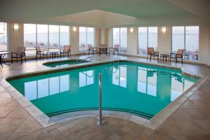 a pool in a hotel lobby with chairs and tables at Sheraton Louisville Riverside Hotel in Jeffersonville