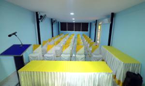 Perintalmanna的住宿－NARMADA HOMESTAY Ganga，一间房间,配有一排椅子和一张带麦克风的桌子