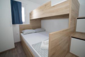 mały pokój z łóżkiem i telewizorem w obiekcie Mobile Home Lana w mieście Murter