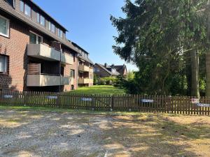 une clôture en bois devant un bâtiment dans l'établissement Stilvolle 2 Schlafzimmer Apartments Heidegarten, Osterheide, Zentrum, à Schneverdingen