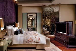 a bedroom with a bed and a flat screen tv at The Ritz-Carlton Shanghai, Pudong in Shanghai