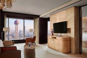 a living room with a television and a large window at The Ritz-Carlton Shanghai, Pudong in Shanghai