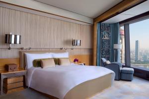 a bedroom with a large white bed and a large window at The Ritz-Carlton Shanghai, Pudong in Shanghai