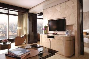 a living room with a television and a large window at The Ritz-Carlton Shanghai, Pudong in Shanghai