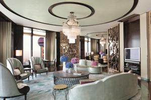 a living room with couches and chairs and a television at The Ritz-Carlton Shanghai, Pudong in Shanghai