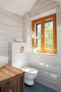 a white bathroom with a toilet and a window at Charming stone villa Silva in Tučepi