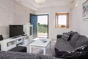een woonkamer met een bank en een tv bij Charming stone villa Silva in Tučepi
