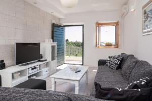 a living room with a couch and a tv at Charming stone villa Silva in Tučepi