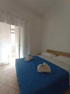 1 Schlafzimmer mit 2 Betten mit Schuhen auf einer blauen Decke in der Unterkunft Casa Ines in Maranola