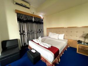 um quarto de hotel com uma cama e uma cadeira em Hotel Milina Uttara em Daca