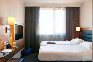 um quarto de hotel com duas camas e uma grande janela em X Hotel em Skjetten