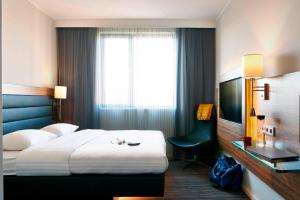 a hotel room with a bed and a television at X Hotel in Skjetten