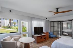 a living room with a bed and a flat screen tv at Sheraton Fiji Golf & Beach Resort in Denarau