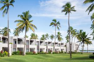 einen Blick nach außen auf ein Resort mit Palmen in der Unterkunft Sheraton Fiji Golf & Beach Resort in Denarau