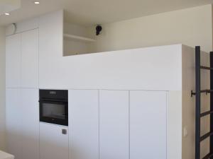 een keuken met witte kasten en een magnetron bij Mayfair 0205 exclusive residence with sea view in De Haan