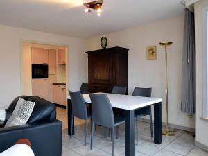uma sala de estar com uma mesa de jantar e cadeiras em Celine 0101 beautiful apartment with sea view em De Haan
