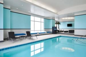 a pool in a hotel room with two chairs and a table at The Westin Virginia Beach Town Center in Virginia Beach