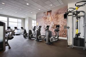 a gym with tread machines and a wall with a mural at The Westin Virginia Beach Town Center in Virginia Beach