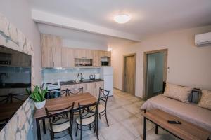 cocina y sala de estar con mesa y sofá en Acrocorinth Apartments en Kórinthos