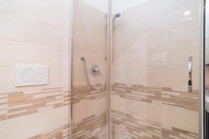 prysznic ze szklanymi drzwiami i cewką prysznicową w obiekcie Royal Rooms - Elegante appartamento nel cuore di Roma w Rzymie