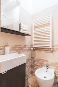 a bathroom with a white sink and a toilet at Royal Rooms - Elegante appartamento nel cuore di Roma in Rome