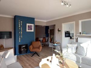 uma sala de estar com um sofá branco e uma parede azul em Dante 0103 furnished apartment with 2 bedrooms em De Haan