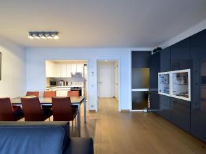 een woonkamer en eetkamer met een tafel en stoelen bij James Ensor 0102 south-facing corner apartment in De Haan