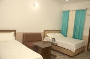 Cette chambre comprend 2 lits et une table. dans l'établissement Panwar Palace, à Uttarkāshi