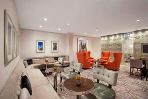 a living room with a couch and orange chairs at Sheraton Philadelphia University City Hotel in Philadelphia
