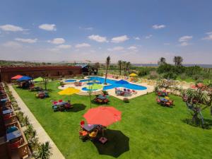 een uitzicht over een park met tafels en parasols bij Tunis Pyramids Hotel - فندق اهرامات تونس in Tunis