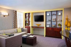 a living room with a couch and a tv at Sheraton Pittsburgh Airport Hotel in Coraopolis