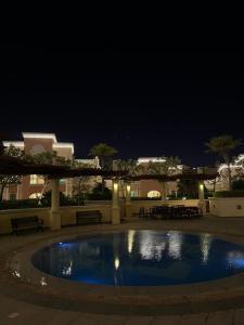 ein Pool im Innenhof in der Nacht in der Unterkunft Beachfront Luxury Apartment-Pearl Island شقه مطله على الشاطئ بجزيرة اللؤلؤه in Doha