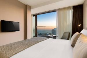 イスタンブールにあるマリオット ACホテル イスタンブール マチカのベッドと大きな窓が備わるホテルルームです。