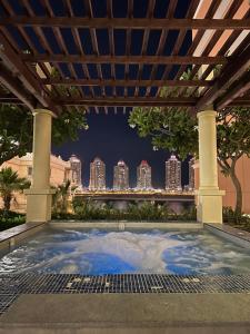 ein Swimmingpool unter einer Pergola mit einer Skyline der Stadt in der Unterkunft Beachfront Luxury Apartment-Pearl Island شقه مطله على الشاطئ بجزيرة اللؤلؤه in Doha