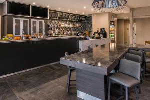 a bar in a restaurant with a counter and chairs at Courtyard by Marriott Temecula Murrieta in Murrieta