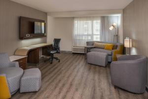 a hotel room with a desk and chairs and a living room at Courtyard by Marriott Temecula Murrieta in Murrieta