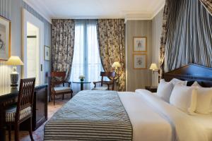 Cette chambre comprend un grand lit et un bureau. dans l'établissement Le Dokhan's Paris Arc de Triomphe, a Tribute Portfolio Hotel, à Paris