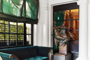 a living room with a couch and a statue at Le Dokhan's Paris Arc de Triomphe, a Tribute Portfolio Hotel in Paris