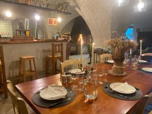 una mesa de madera con platos y servilletas. en Maison d’hôtes les Méans, en Méolans