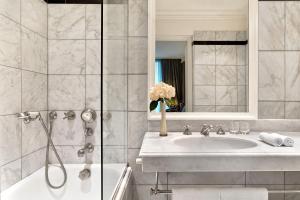 y baño con lavabo y bañera. en Le Dokhan's Paris Arc de Triomphe, a Tribute Portfolio Hotel, en París