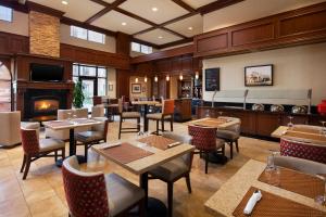 a restaurant with tables and chairs and a fireplace at Four Points by Sheraton, Ontario-Rancho Cucamonga in Rancho Cucamonga