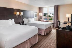 a hotel room with two beds and a desk at Delta Hotels by Marriott Sault Ste. Marie Waterfront in Sault Ste. Marie
