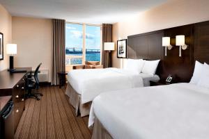 a hotel room with two beds and a desk at Delta Hotels by Marriott Sault Ste. Marie Waterfront in Sault Ste. Marie